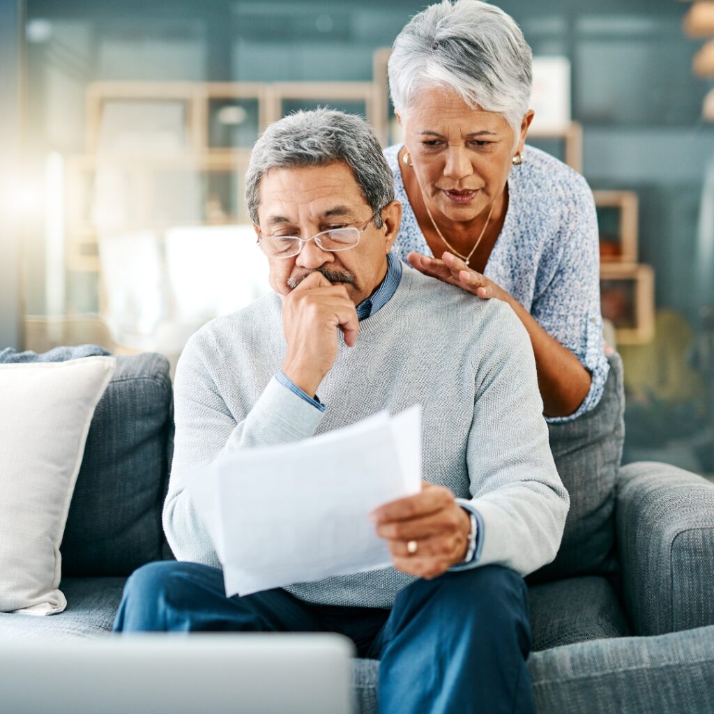 An older couple looking at finances in a worried way